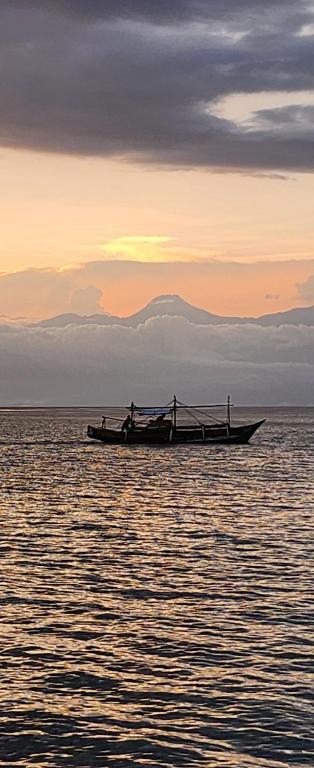 a boat in the middle of the water at sunset at GEM Crystal Water Resort in Davao City