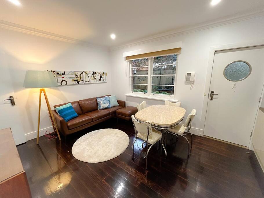 a living room with a couch and a table at East Melbourne unit with courtyard in Melbourne