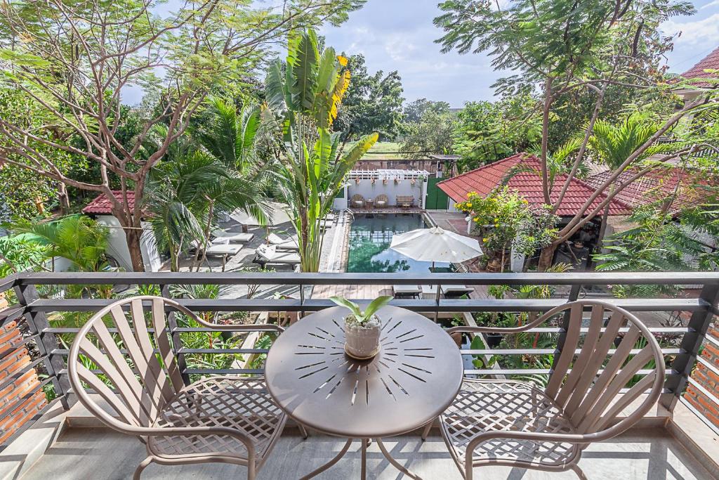 una mesa y sillas con una planta en el balcón en Angkor Eden Boutique Hotel en Siem Reap