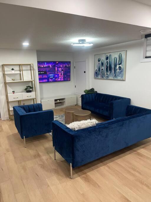 a living room with a blue couch and two chairs at Modern 2Bedroom suite in SW Edmonton close to Edmonton International Airport in Edmonton