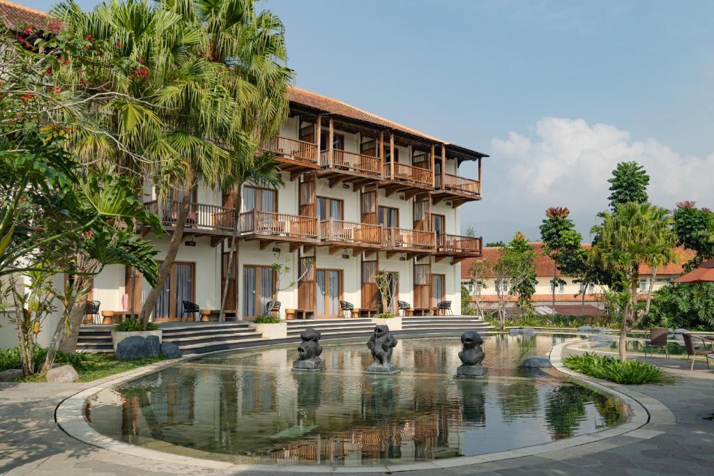 un bâtiment avec une fontaine en face d'un bâtiment dans l'établissement Novus Giri Resort & Spa, à Puncak