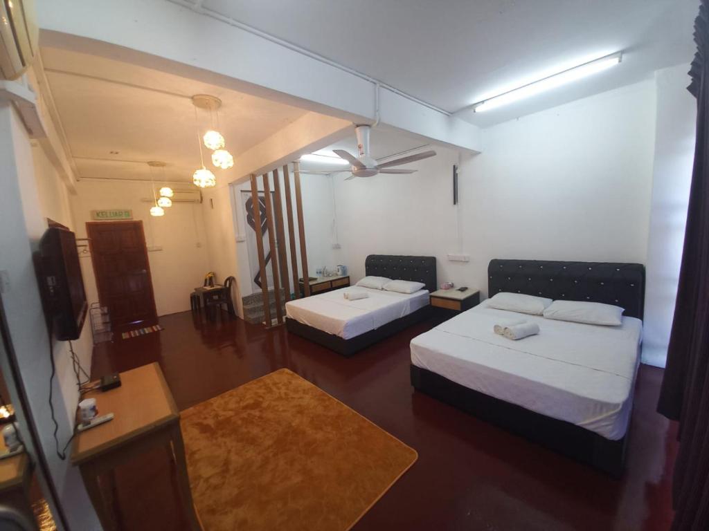 ein Hotelzimmer mit 2 Betten und einem TV in der Unterkunft Musafir Transit Hotel in Nilai