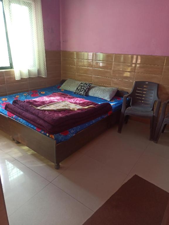 ein Bett und ein Stuhl in einem Zimmer in der Unterkunft Shivalik guest house in Dhanaulti