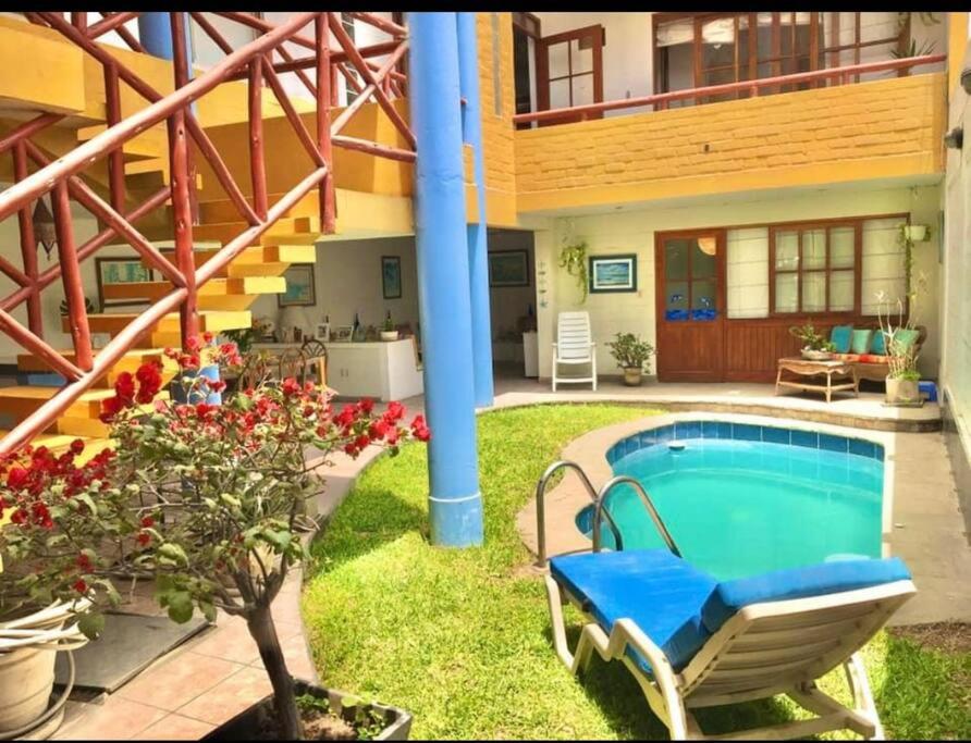 una casa con piscina en el patio en Casa amarilla PH depa 2dorm 3er piso, en Punta Hermosa