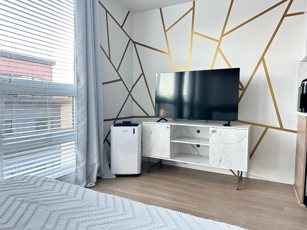 a bedroom with a television on a white dresser at Downtown Glamorous Lifestyle in Tacoma The apartment near the convention center, Free Netflix , King size bed & futon sofa bed , AC, Great Amenities Rooftop, self-check-in in Tacoma