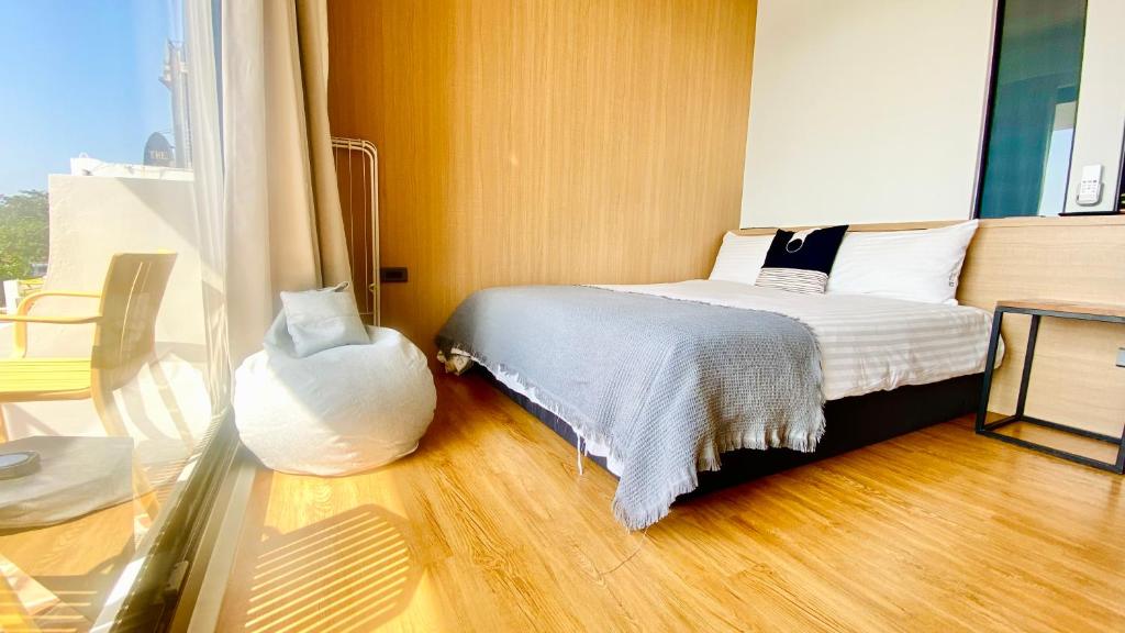 a bedroom with a bed and a table and a window at Mini Summer in Nanwan
