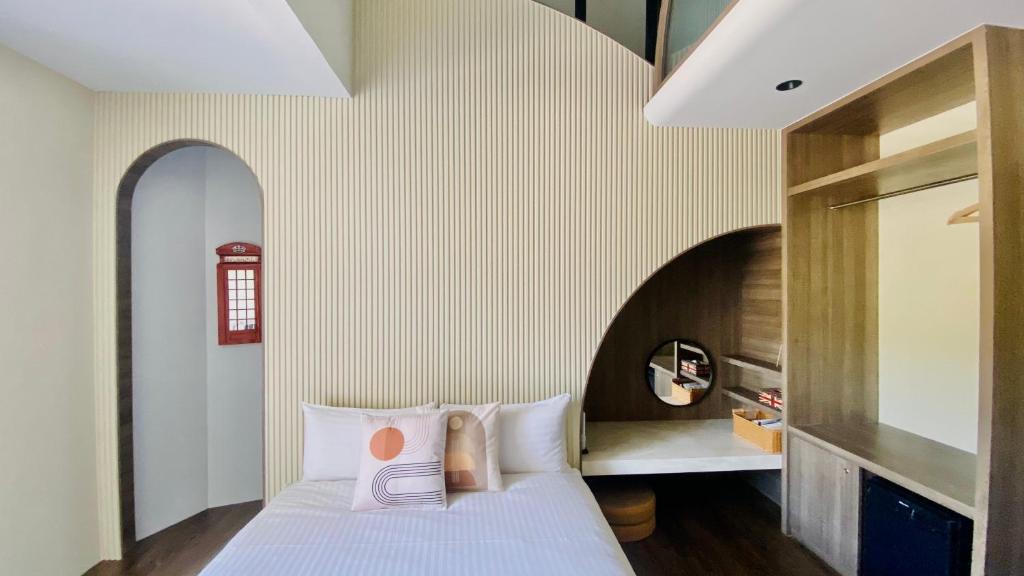 a bedroom with a white bed and an arched wall at Mini Summer in Nanwan