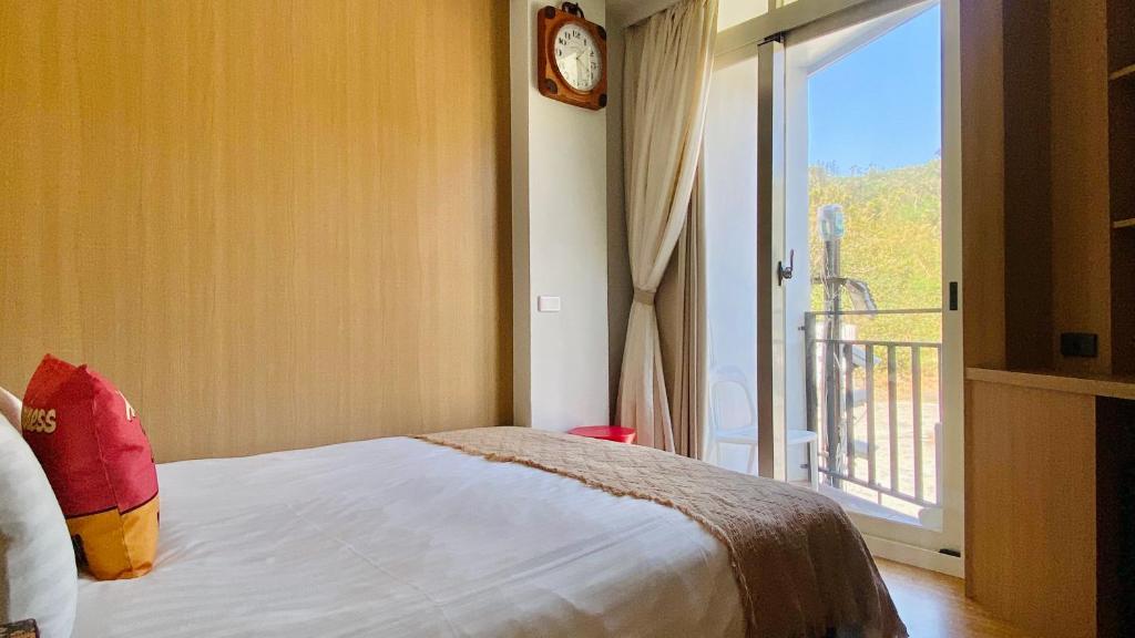 a bedroom with a bed and a window with a balcony at Mini Summer in Nanwan