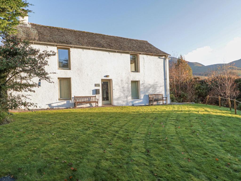 a large white house with a large grass yard at Low Melbecks House in Keswick