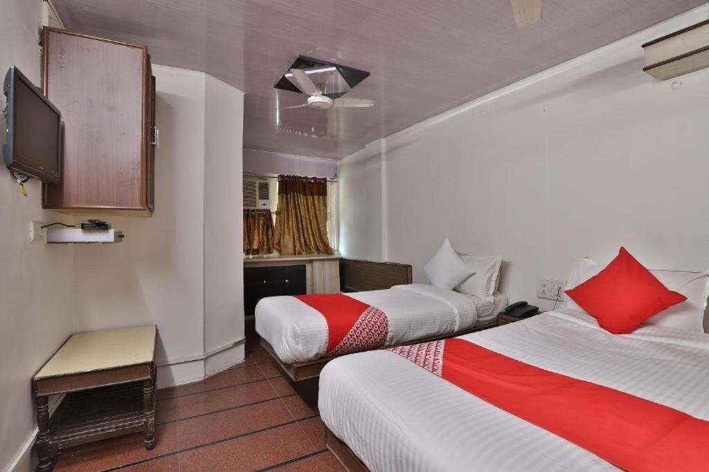 a hotel room with two beds and a television at Hotel Maninagar Residency in Ahmedabad