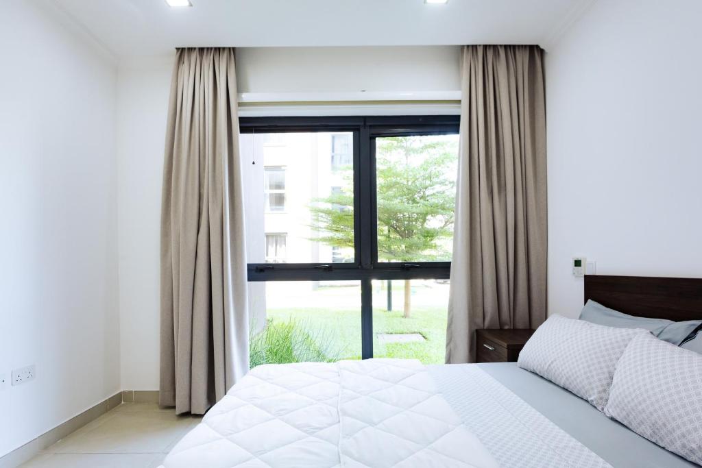 a bedroom with a bed and a large window at Nice 3 bedroom Apartment Space Available in Accra