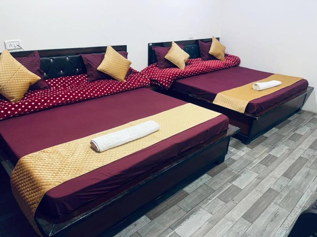 two beds sitting next to each other in a room at Badrinath B V by prithvi yatra hotels in Badrinath