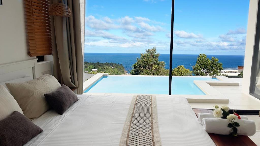 a bedroom with a bed and a view of a swimming pool at Infinity Villa in Salad Beach