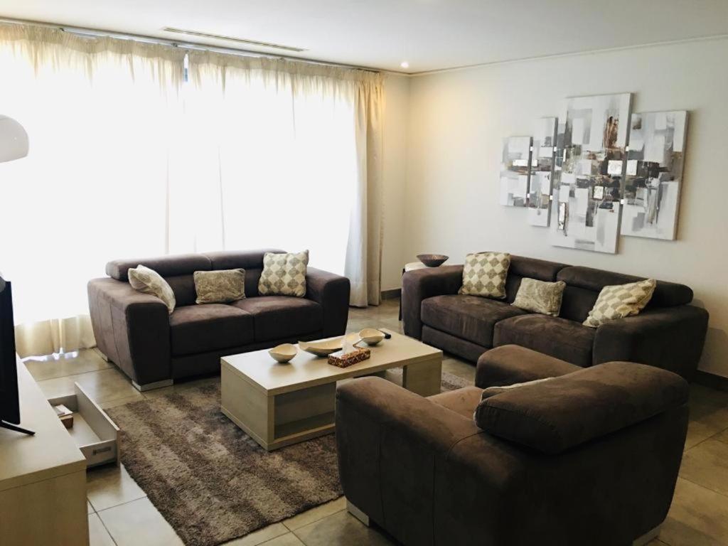 ein Wohnzimmer mit 2 Sofas und einem Couchtisch in der Unterkunft Executive 2 bedroom Apartment At East Legon in Accra