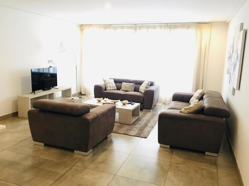 a living room with two couches and a tv at Incredible one bedroom space at East Legon in Accra