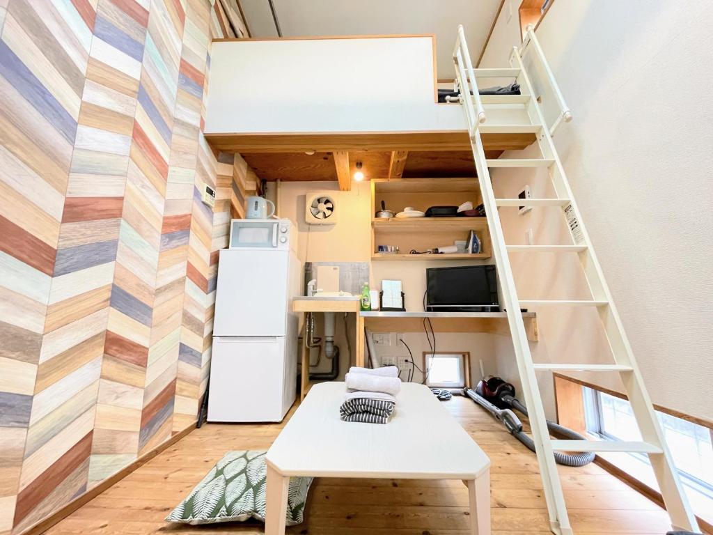 een kamer met een hoogslaper en een koelkast bij Kanamechō detached house in Tokyo