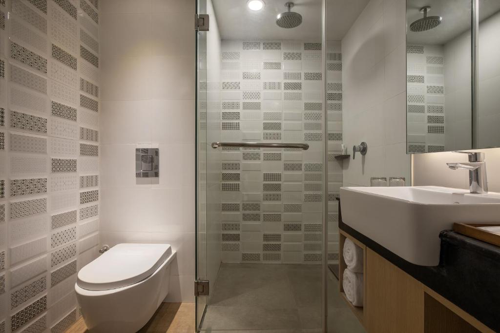 a bathroom with a toilet and a sink and a shower at Aveta Hotel Malioboro in Yogyakarta