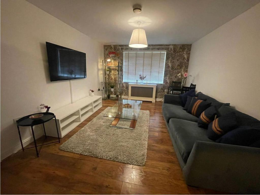 a living room with a couch and a television at Woolwich 2Bedroom Apartment in London