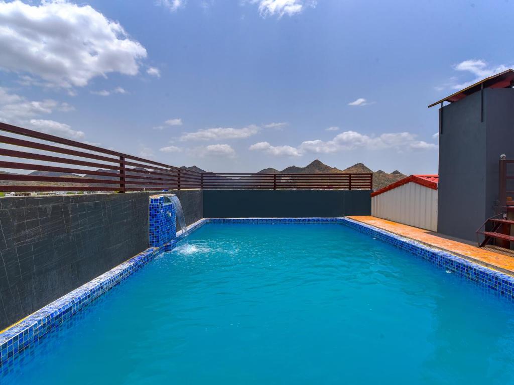 a swimming pool with blue water on a building at Mangal Residency Rooftop Pool in Udaipur