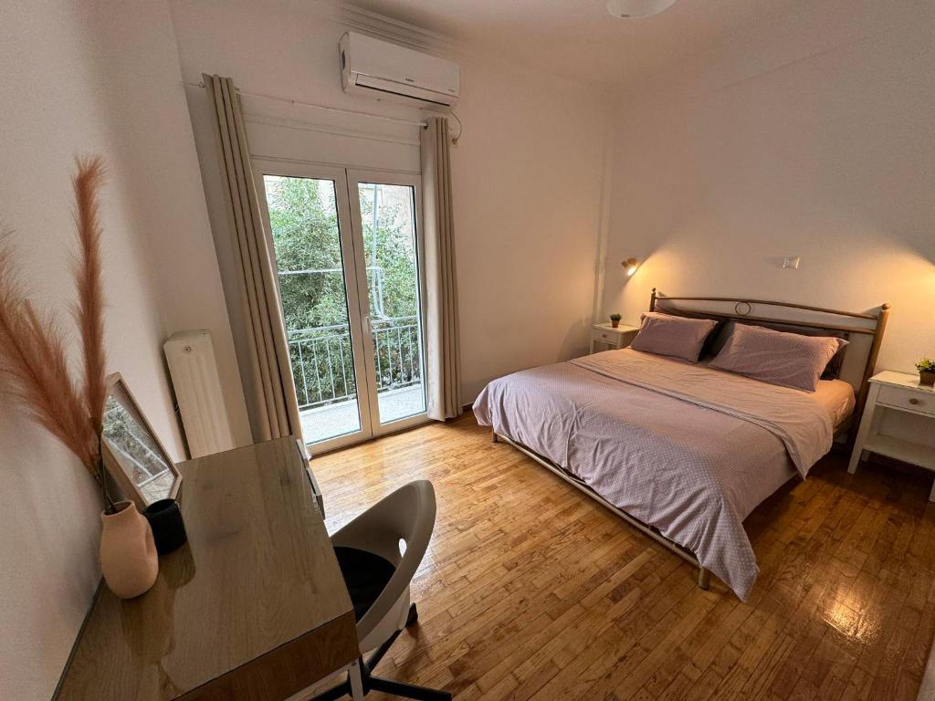 een slaapkamer met een bed, een bureau en een raam bij Noula's Home in Athene