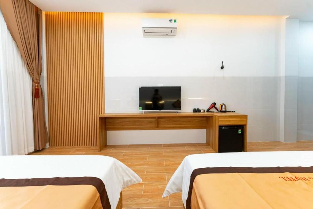 een kamer met 2 bedden en een flatscreen-tv bij KHÁCH SẠN HÀ PHƯƠNG Tánh Linh in Phan Thiet