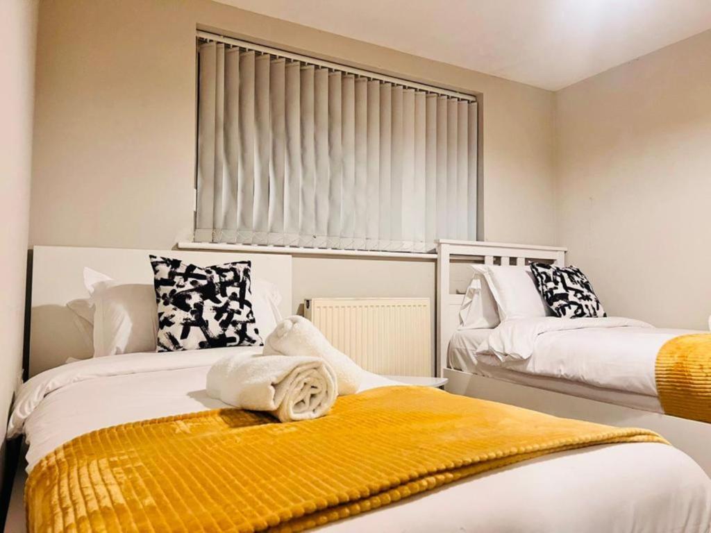a bedroom with two beds and a window at Exquisite 2 bedroom, Sleeps 4, Wifi LONG STAY WORK LEISURE CONTRACTOR - Lolite Apartment in Cambridge