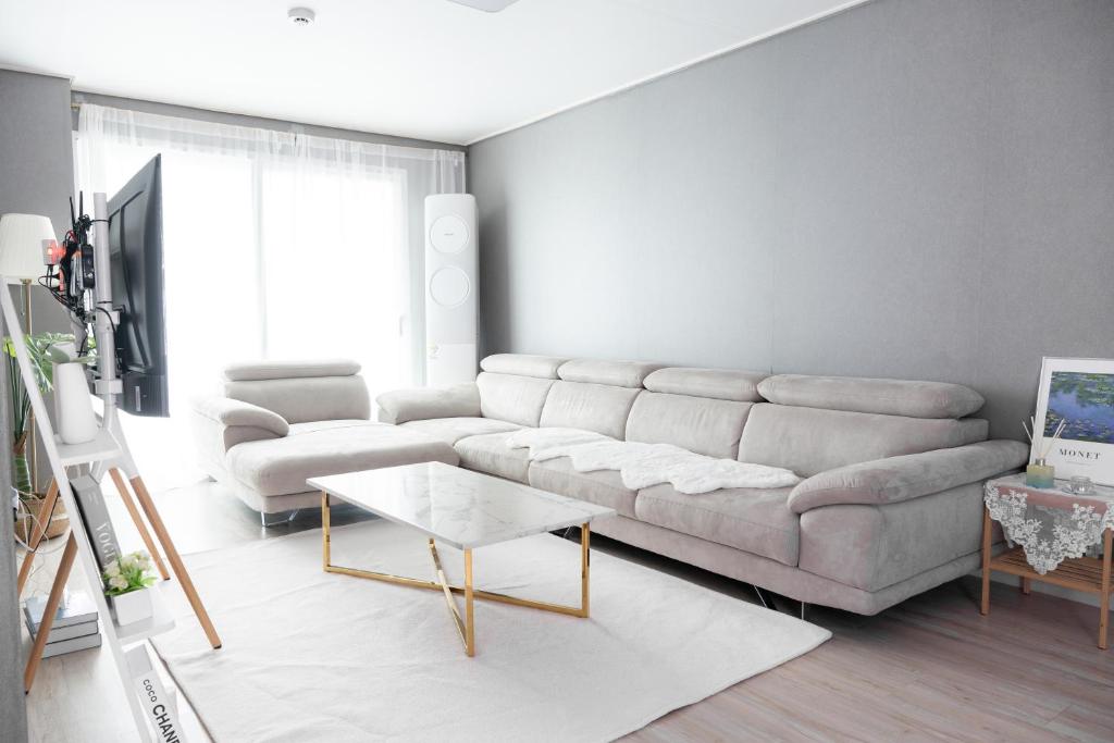 ein Wohnzimmer mit einem Sofa und einem Tisch in der Unterkunft Goose Stay in Bucheon