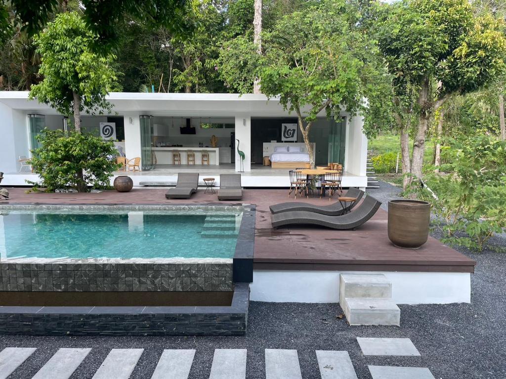 a villa with a swimming pool and a house at KPG Suite Dream in Ban Nua