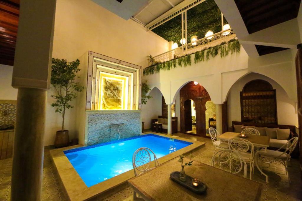 - une grande piscine dans une chambre avec une maison dans l'établissement Riad Oum B&B, à Marrakech
