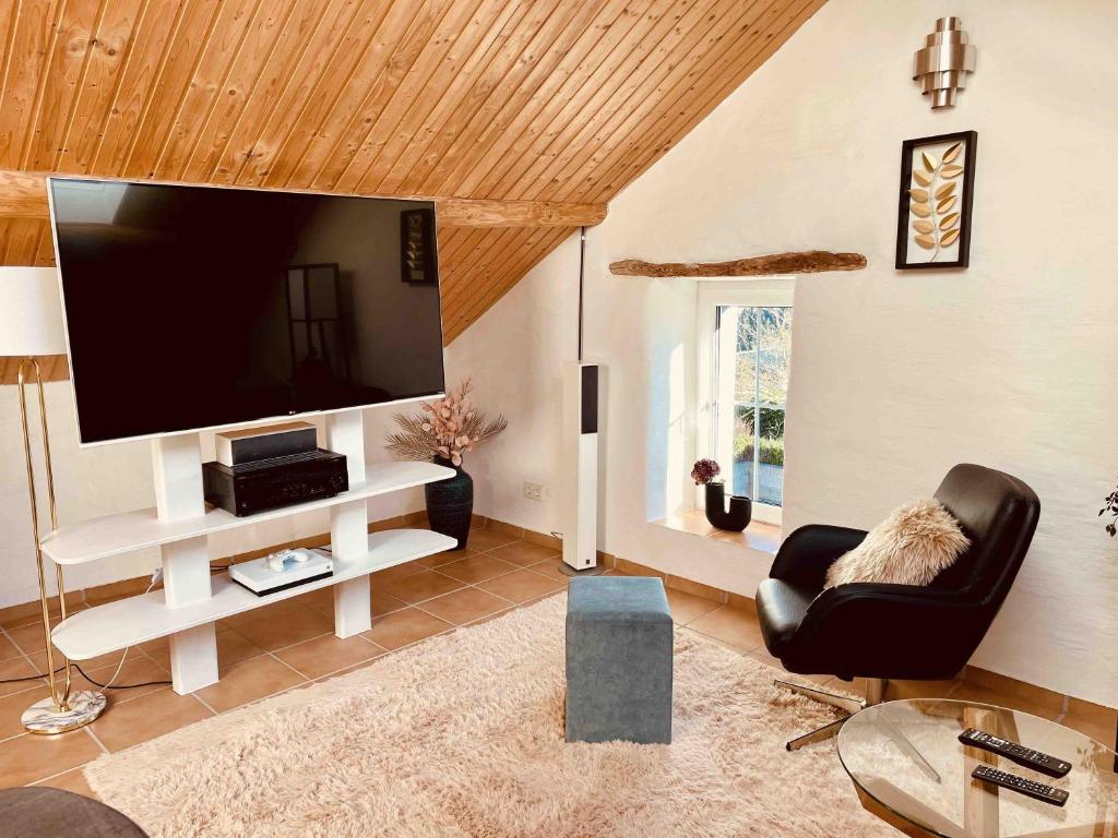 uma sala de estar com uma grande televisão de ecrã plano em Altes Backhaus in der Eifel em Feuerscheid
