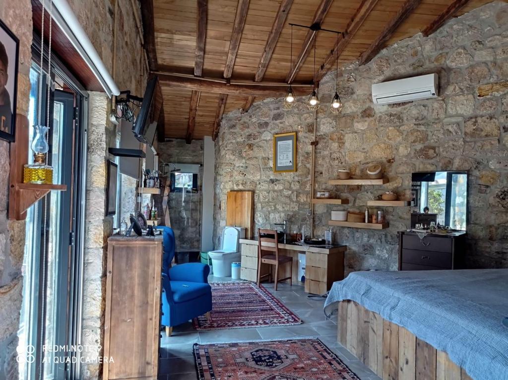 1 dormitorio con 1 cama en una pared de piedra en taş ev, en Karaburun