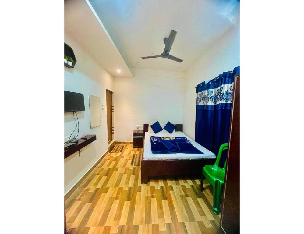 een slaapkamer met een bed en een plafondventilator bij Hotel Royal City, Chakchaka, WB in Koch Bihār