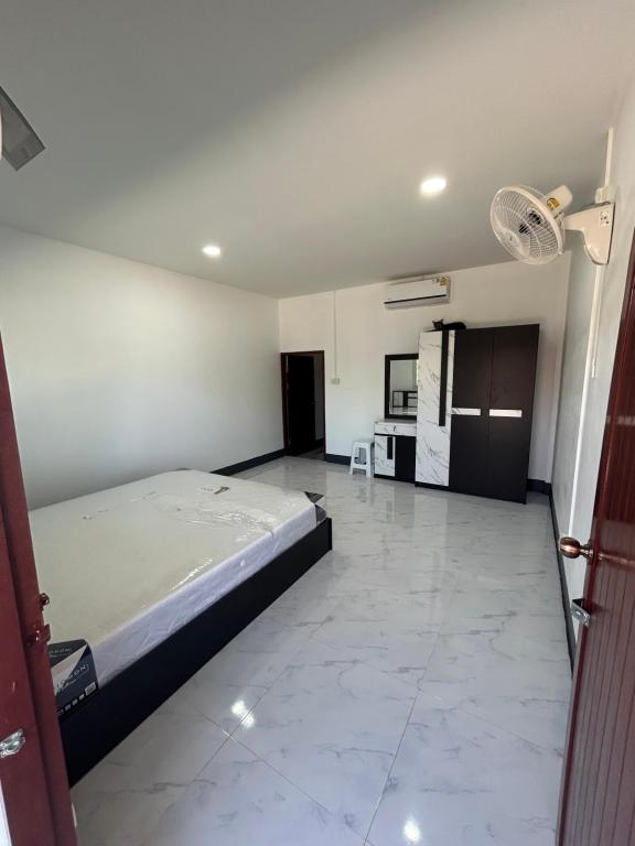Großes Zimmer mit einem Bett und einer Küche. in der Unterkunft หอพักนฤมล in Bung Kan