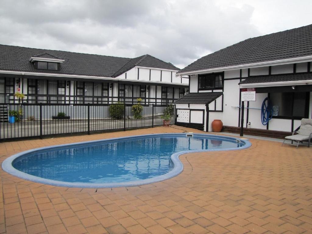 a swimming pool in front of a building at Devonwood Motel in Rotorua