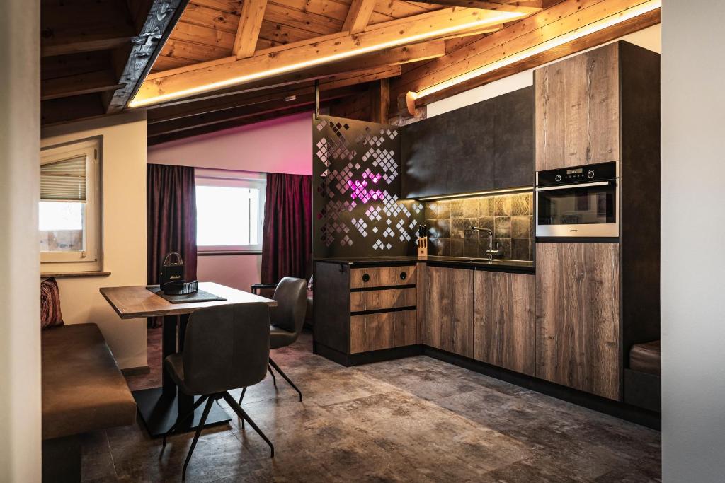 a kitchen with wooden cabinets and a table at PHILSON Apartments in Saalbach Hinterglemm