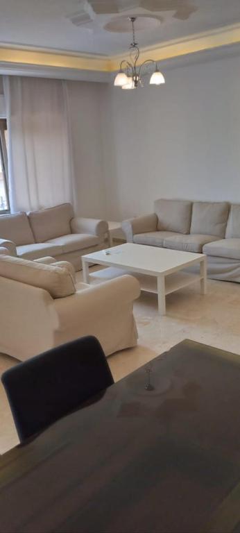 a living room with couches and a coffee table at Al- Kalouti Real Estate in Amman
