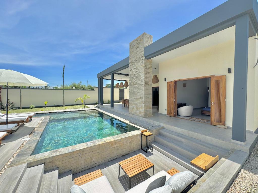 a villa with a swimming pool and a house at Villa Cas' Ylang Nosy Be in Nosy Be