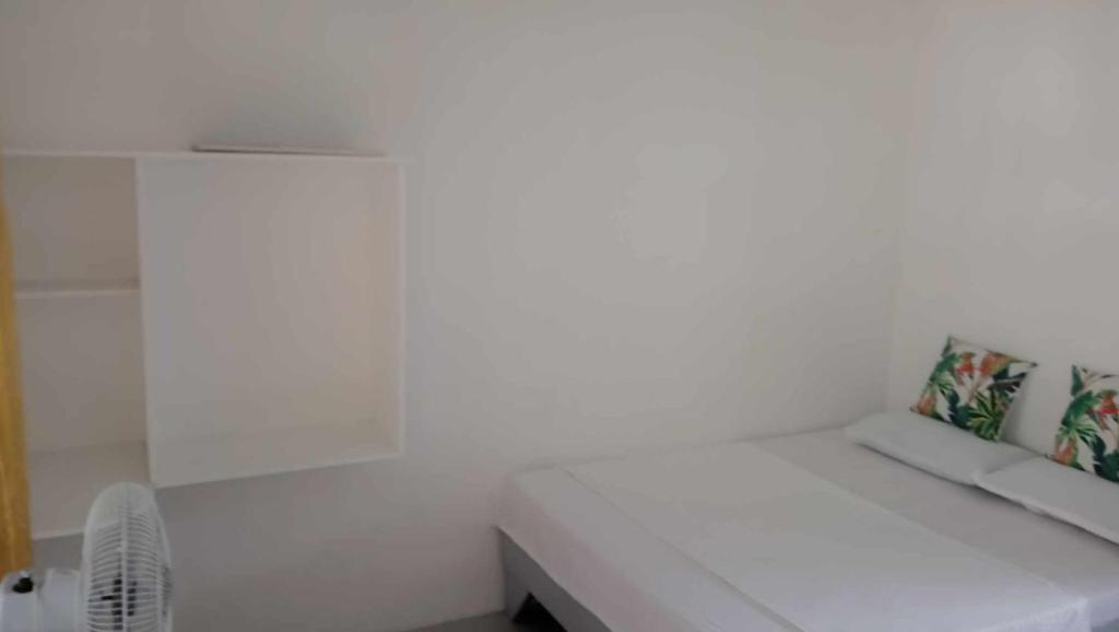 Cette chambre comprend un banc blanc et un ventilateur. dans l'établissement Kaye En Em Apartelle, à Puerto Galera
