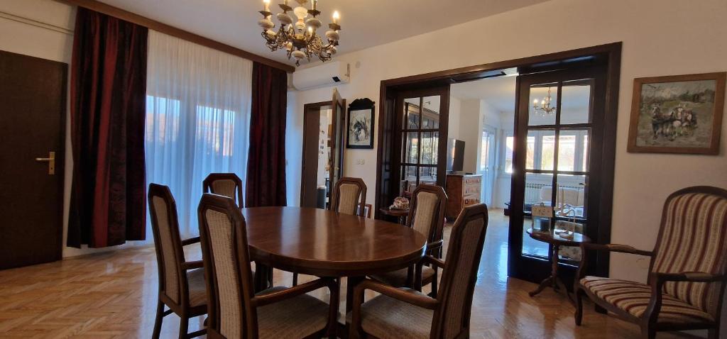 a dining room with a wooden table and chairs at Villa "CENTRAL VILLAGE" in Županja