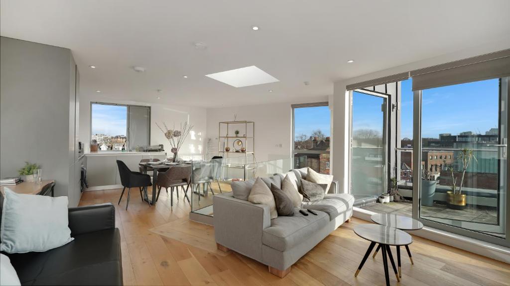 a living room with a couch and a table at Modern and Spacious Penthouse Apartment in Putney with Free Parking in London