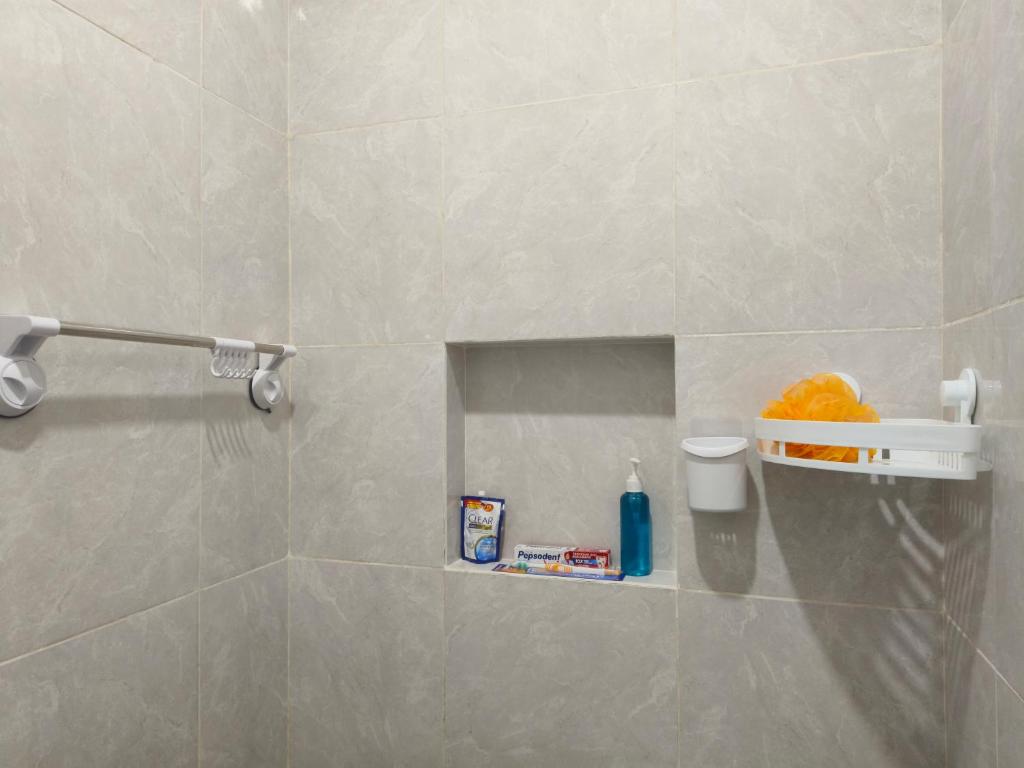 bagno con doccia piastrellata e mensola di Justin Guest House a Jimbaran