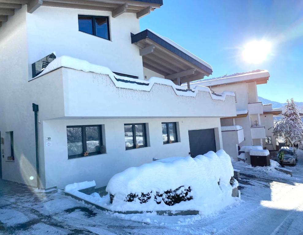 une maison recouverte de neige sur son côté dans l'établissement Alpenapart Gastl, à Arzl im Pitztal