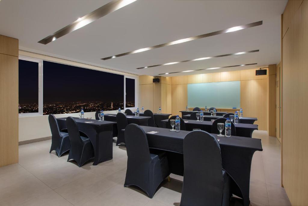 a conference room with black tables and chairs at Aveta Hotel Malioboro in Yogyakarta