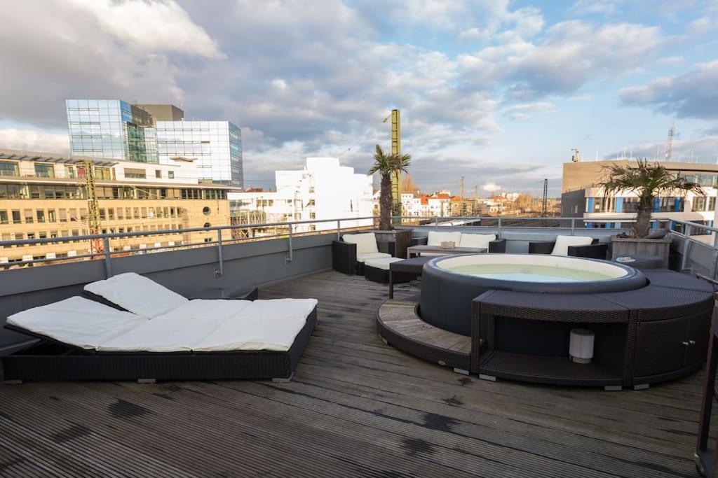 a rooftop patio with a hot tub and tables at City-Loft with rooftop terrace - 19 persons in Hannover