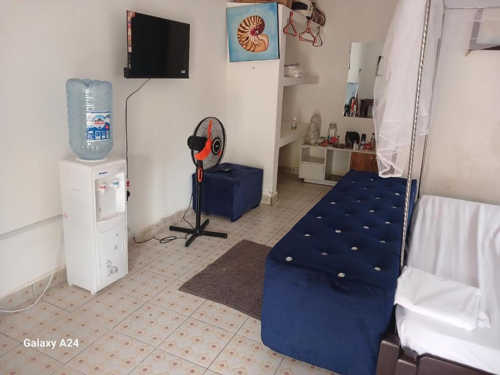 Zimmer mit einem Bett und einem Ventilator in der Unterkunft Hideout in Ukunda