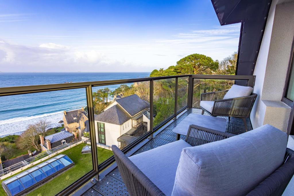 a balcony with chairs and a view of the ocean at L'Agapa Hôtel - Spa Codage in Perros-Guirec