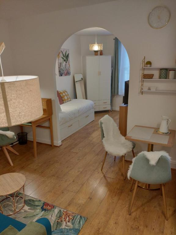a living room with a bed and a table at Appartement tout équipé au cœur de Fontainebleau in Fontainebleau
