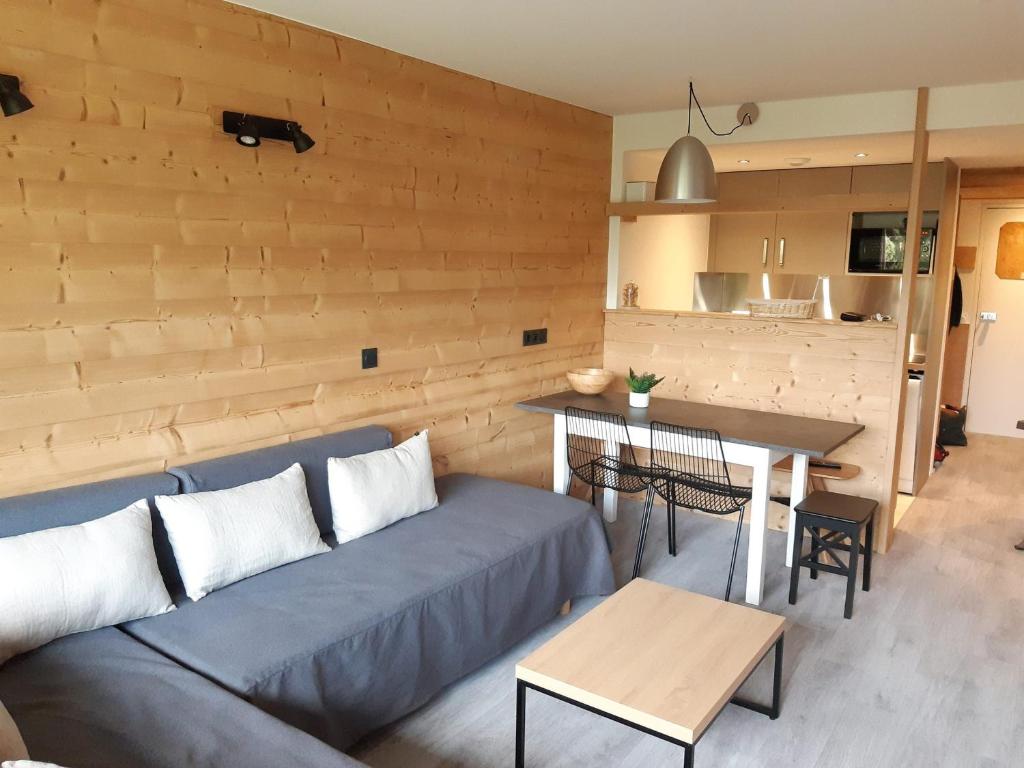 a living room with a blue couch and a table at Appartement rénové 2 pièces cabine avec balcon - 6 personnes - Wifi inclus - FR-1-346-558 in Arc 1800