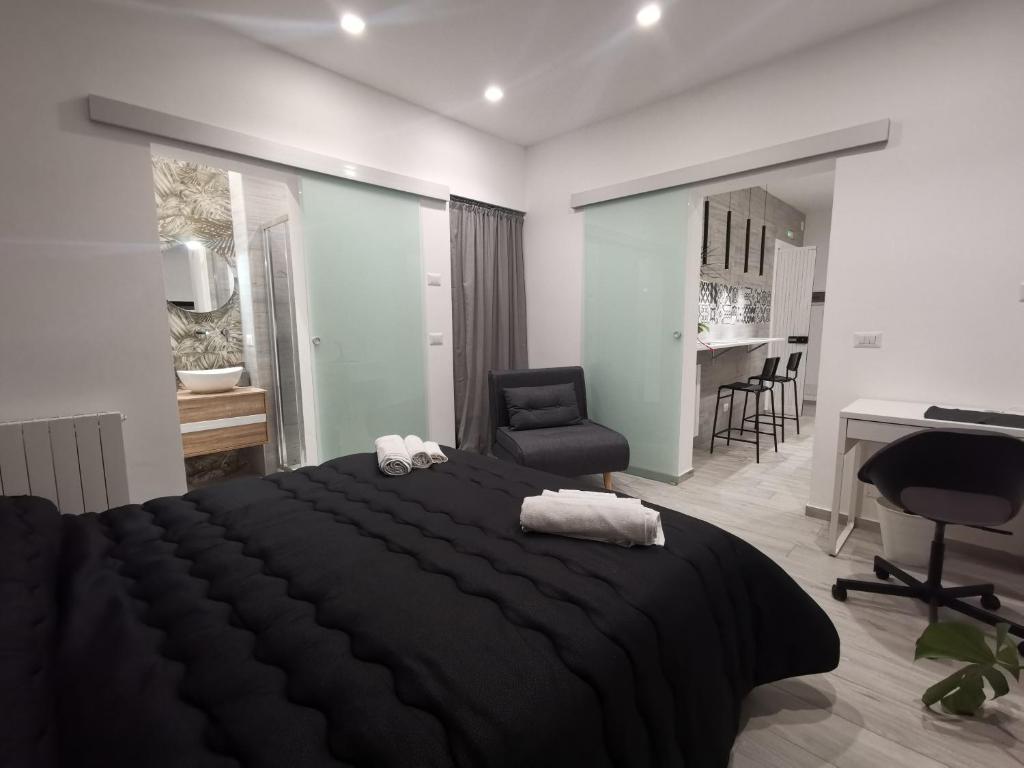 1 dormitorio con 1 cama negra grande y escritorio en Trinity Apartment, en Catania