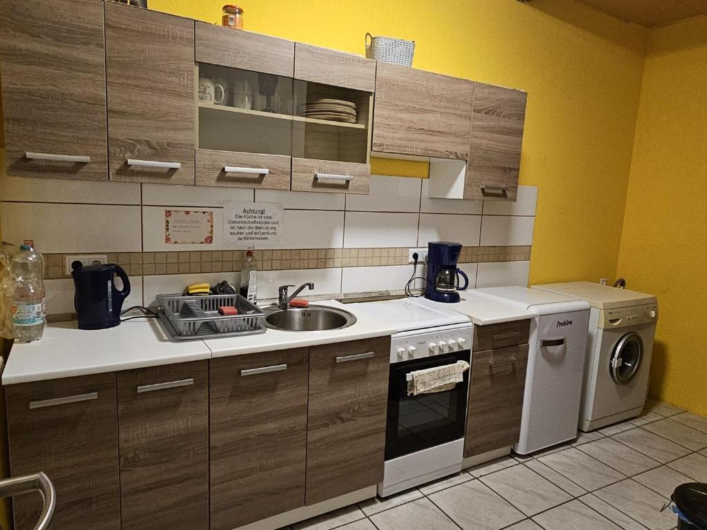 a kitchen with a sink and a washing machine at Monteurzimmer und Pension - Ampfurth in Oschersleben